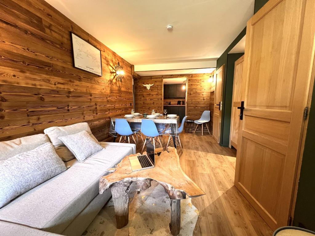 un soggiorno con un divano e un tavolo di Chalet Détente a La Plagne Tarentaise