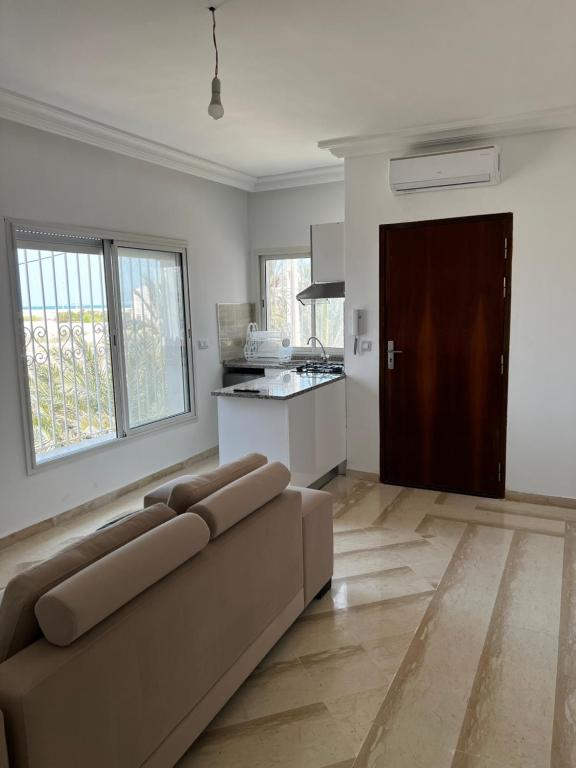a living room with a couch and a kitchen at Djerba Apparts in Djerba