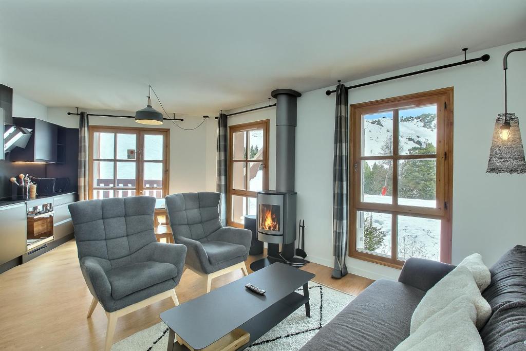 a living room with a couch and chairs and a table at ARC 1950, Appartement 2 chambres, 6 personnes, Exposition Sud, SAUNA, HAMMAM, JACUZZI, PISCINE in Arc 1950