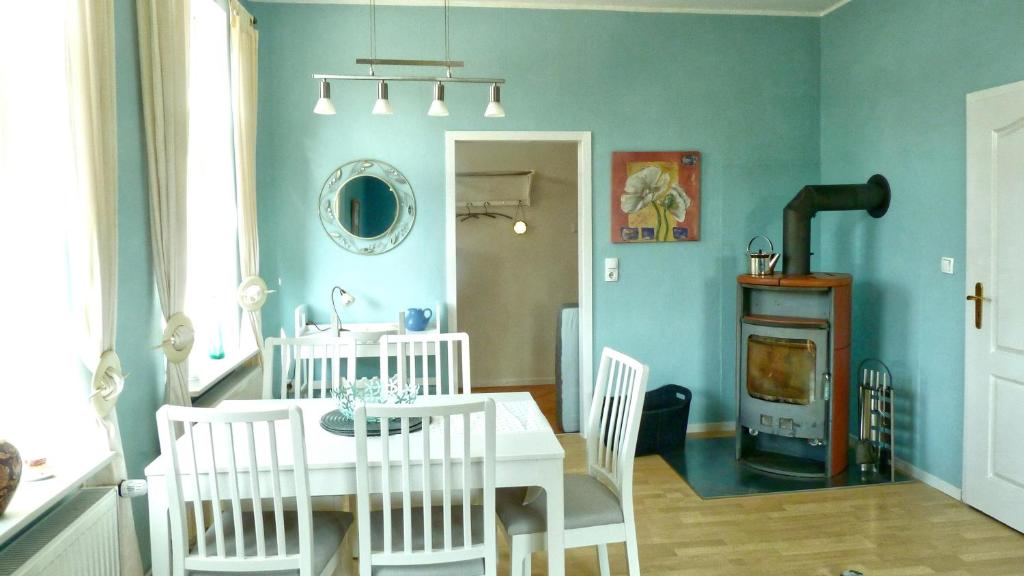 a dining room with a table and chairs and a stove at blue lagoon in Fehmarn