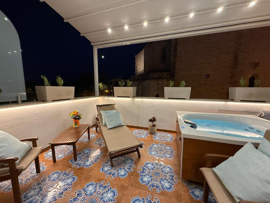 a room with a tub and a table and chairs at Manna Blue Sky - Apulian Suites in Barletta