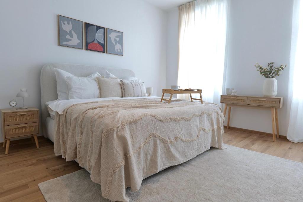 a white bedroom with a large bed with a blanket at Apartment Grace Family in Vienna