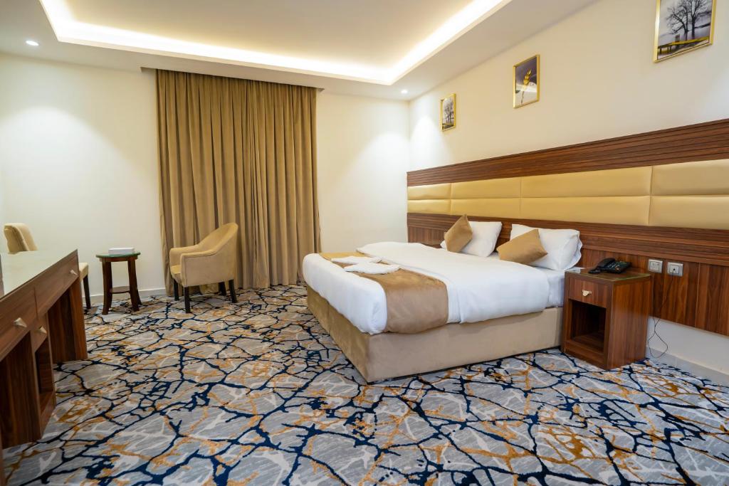 um quarto de hotel com uma cama e uma escrivaninha em فندق منازل المقام em Al Khansāk