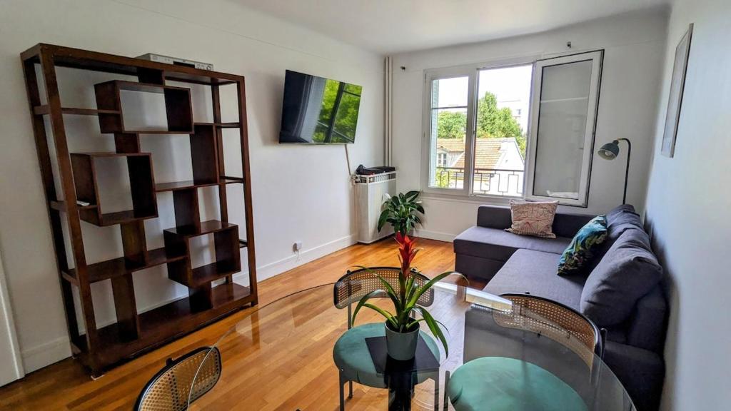 a living room with a couch and a table at Apt 2 pièces, 2 lits, à 15' Paris centre, 30' Disney in Vincennes