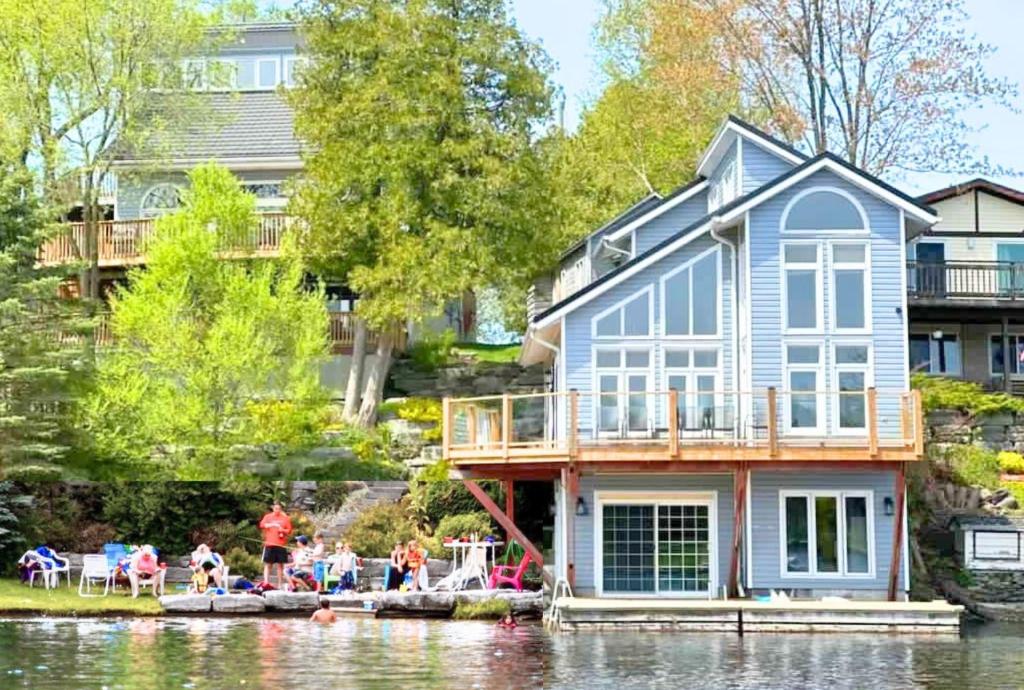 une maison sur l'eau avec des gens sur le quai dans l'établissement Kawartha Lakes, Fenelon Falls, à Fenelon Falls