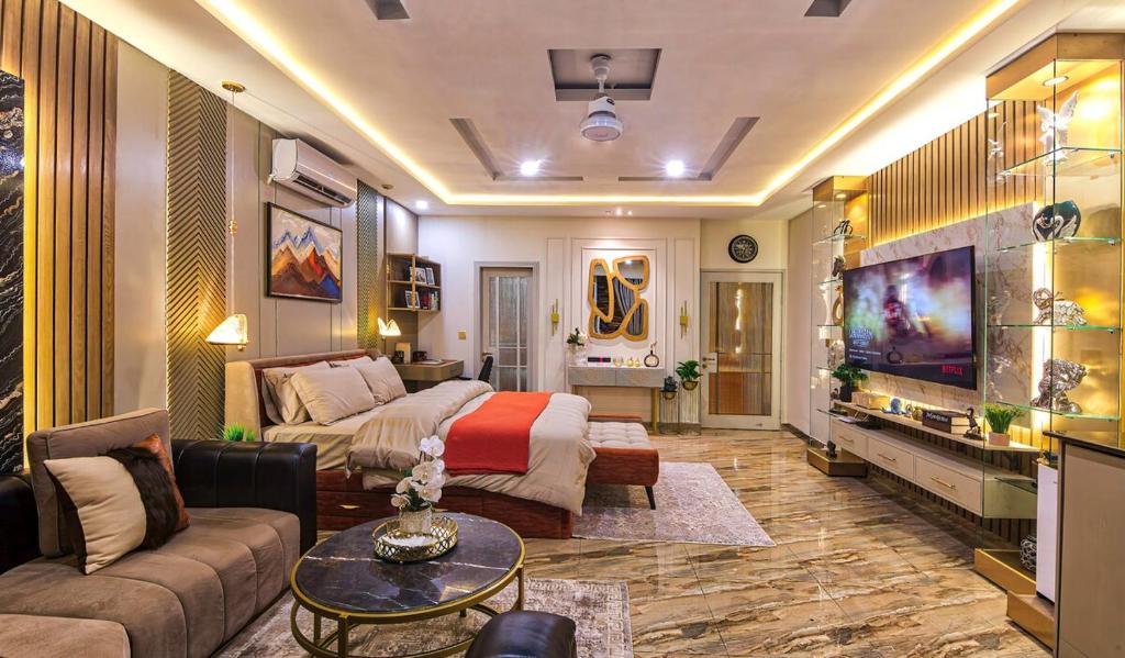 a living room with a couch and a tv at Designer Suite Centrally Located in Islamabad
