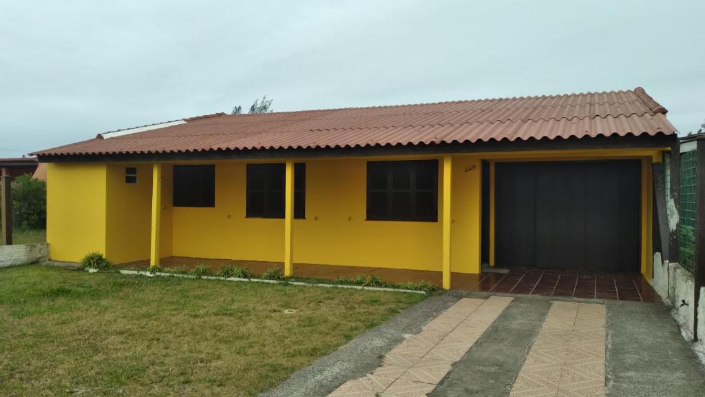 a yellow house with a brown roof at CASA COM 3 QUARTOS, SENDO 1 QUARTO Suite in Pinhal