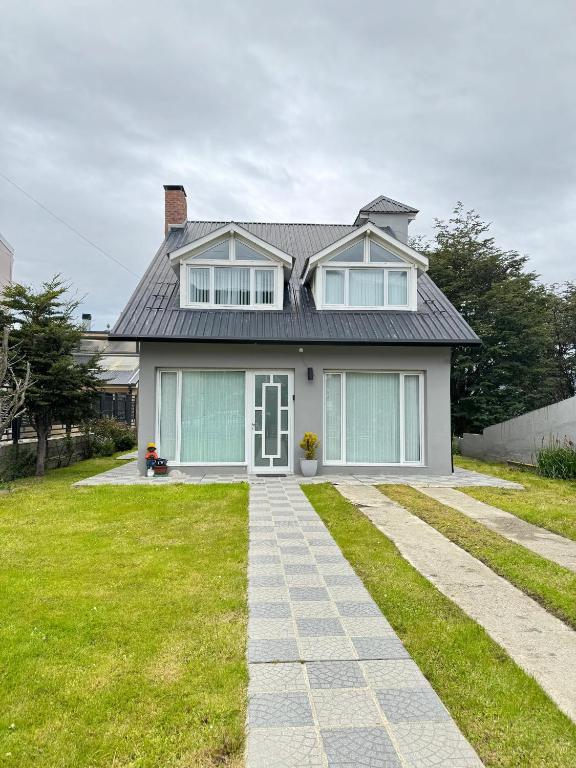 a white house with a gray roof at Casa en Cumbres in Ushuaia