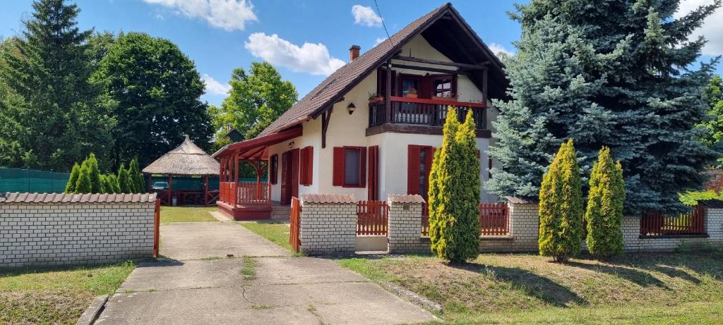a house with a porch and a fence at Tisza-Tavi Isteni Vendégház in Abádszalók