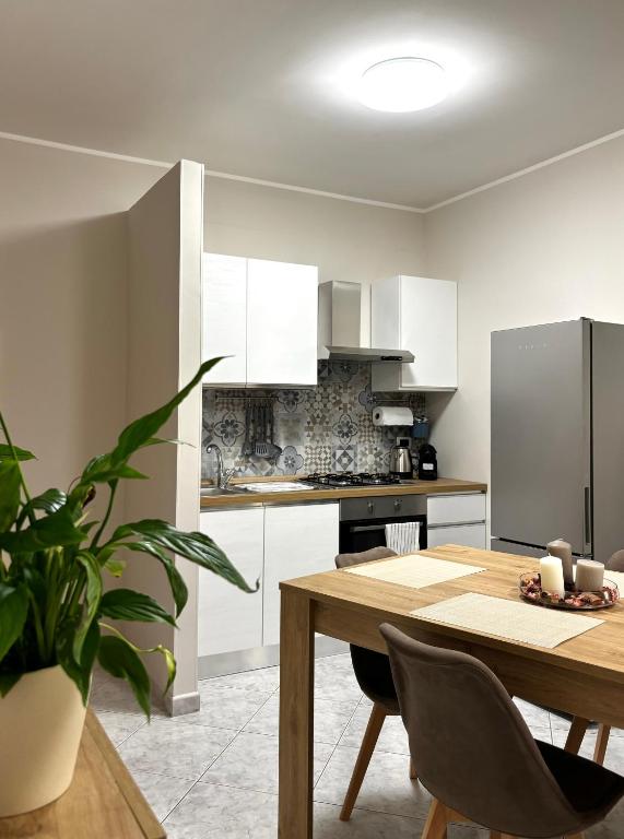a kitchen with white cabinets and a wooden table at Dimora Speranza in San Giovanni Teatino