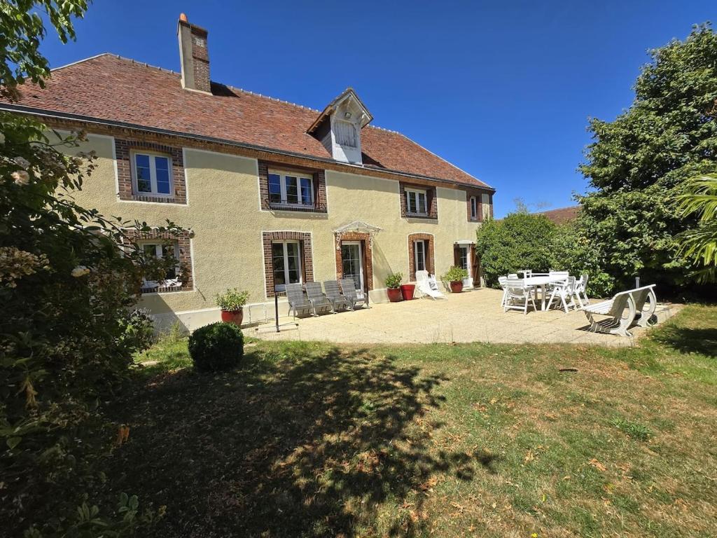 a house with a table and chairs in front of it at Campagne normande en famille in Verneuil d’Avre et d’Iton