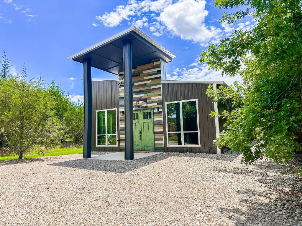 a small house with a green door on a gravel driveway at New Bison Cabin Hot Tub Air Hockey Pool Table in Purcell