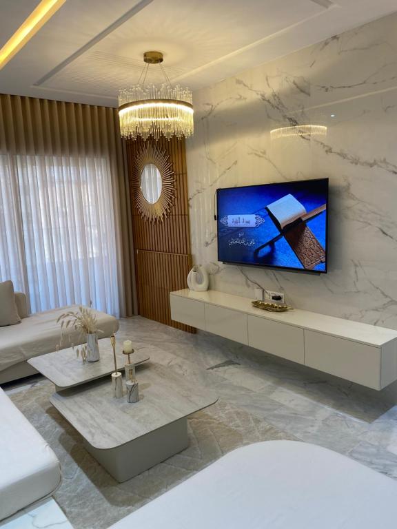 a living room with a tv on a marble wall at Luxury Apartment two bedroom - sea view - best spot in sousse in Sousse