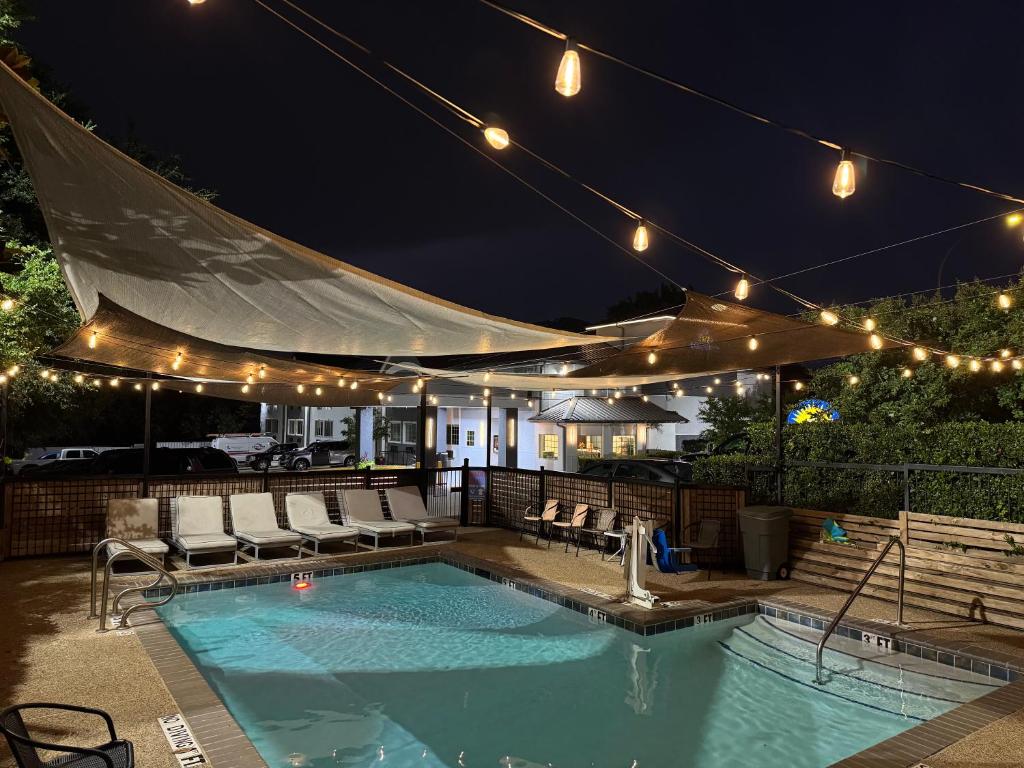 a swimming pool at night with lights on a patio at Days Inn by Wyndham Arlington in Arlington