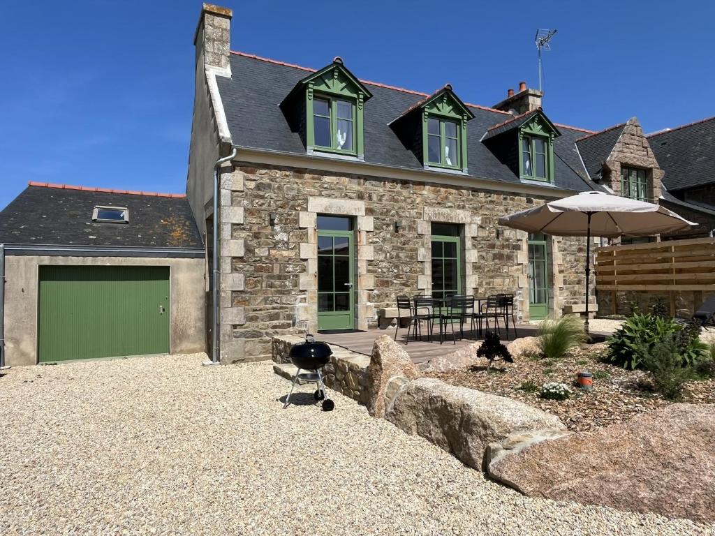 ペロス・ギレックにあるTI GWER - Superbe maison en pierre Ploumanachの緑のガレージと傘のある石造りの家
