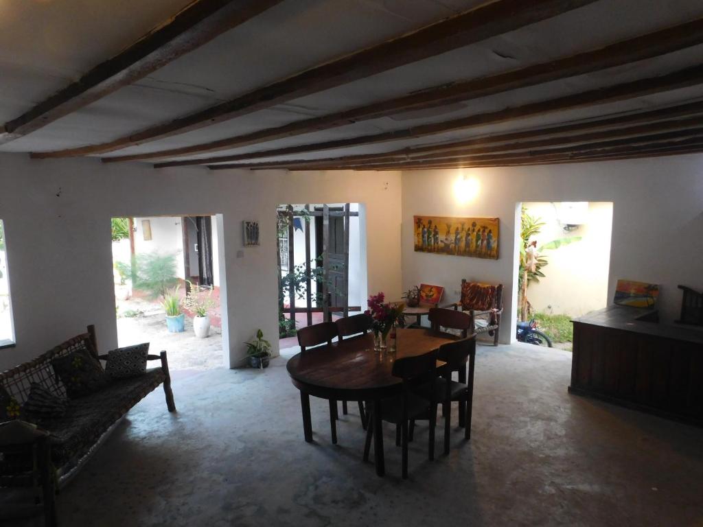 un soggiorno con tavolo e sedie in legno di Paje lounge a Paje