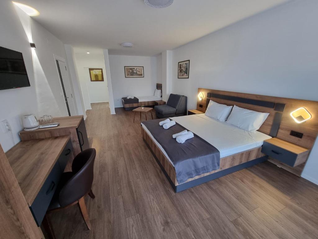 a bedroom with a large bed and a living room at LUX - Rooms Apartments in Struga