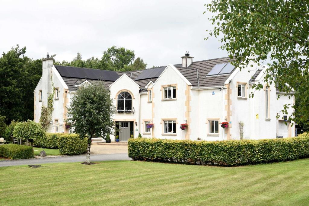 a large white house with a black roof at Dungimmon House in Ballyconnell