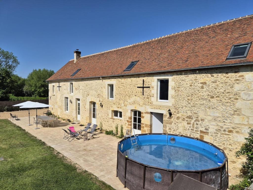 a building with a hot tub in front of it at Confort & nature, calme et convivial in Bazoches-sur-Hoëne