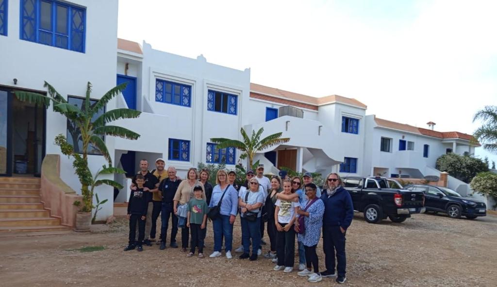 a group of people standing in front of a house at Appartement Le Sable Uniquement les familles in Oualidia