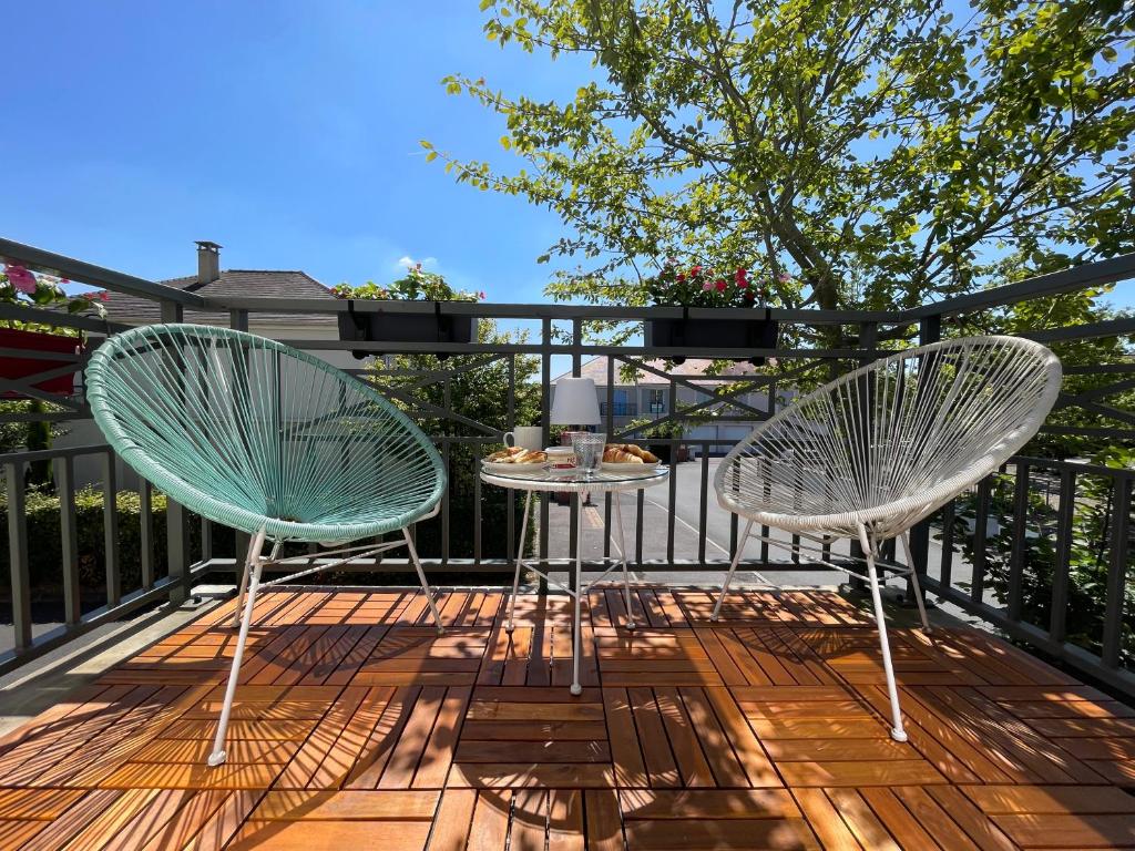 two chairs and a table on a deck at Duplex Moderne 8per&3Ch&10 min Disney&Parking free in Magny-le-Hongre
