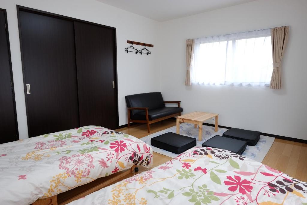 Cottage Kutsuroki في ياكوشيما: غرفة نوم بسريرين وكرسي