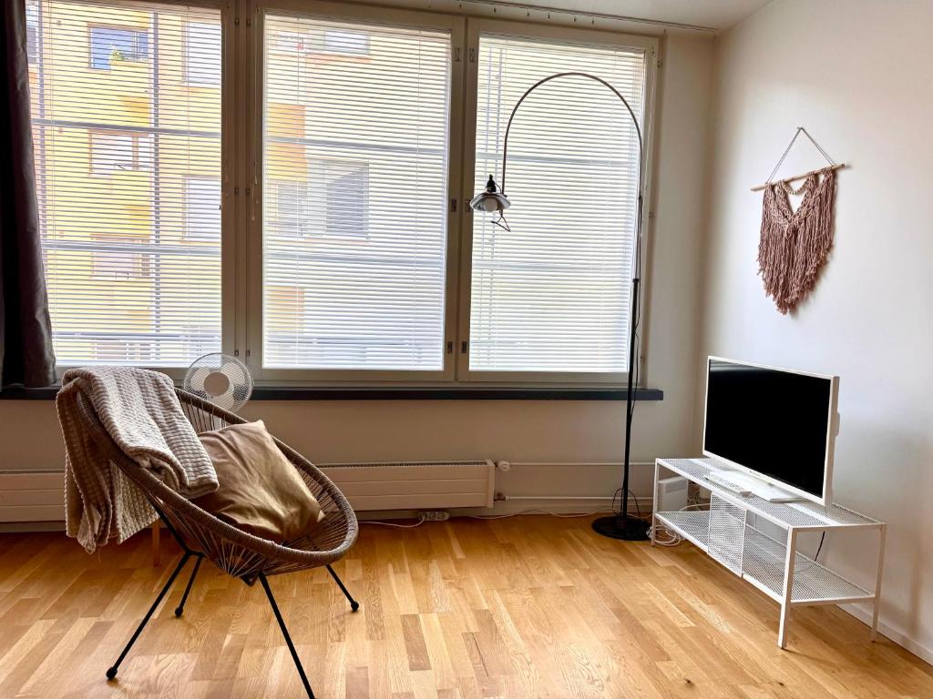 Una sala de estar con una silla y un televisor. en Downtown Suite, en Helsinki