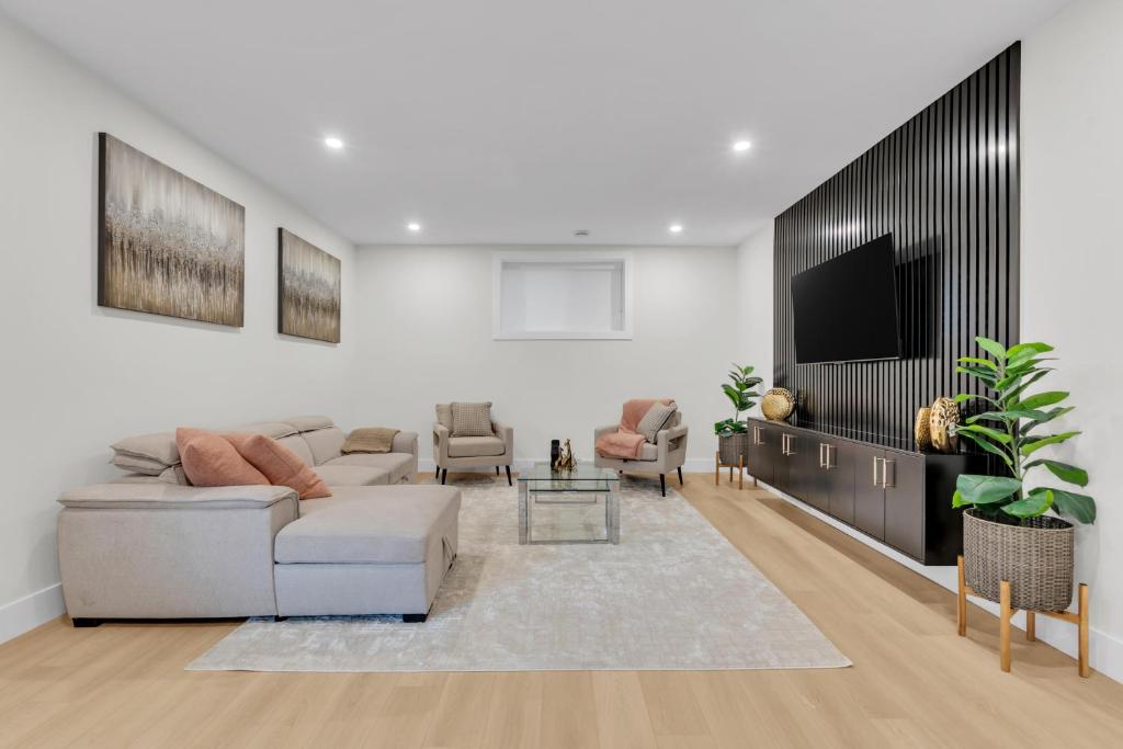 Una sala de estar con un sofá y un televisor. en Cozy 1BR Pullout Couch Discovery Ridge, en Calgary