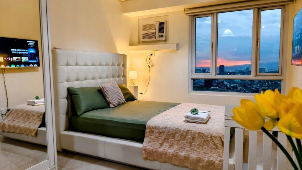 a small bedroom with a bed and a window at Bella Suite Netflix Pool Great View in Manila