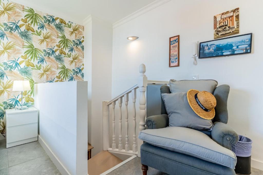 une chambre de bébé avec une chaise bleue et un berceau dans l'établissement City center Studio penthouse near the beach, à Puerto de la Cruz