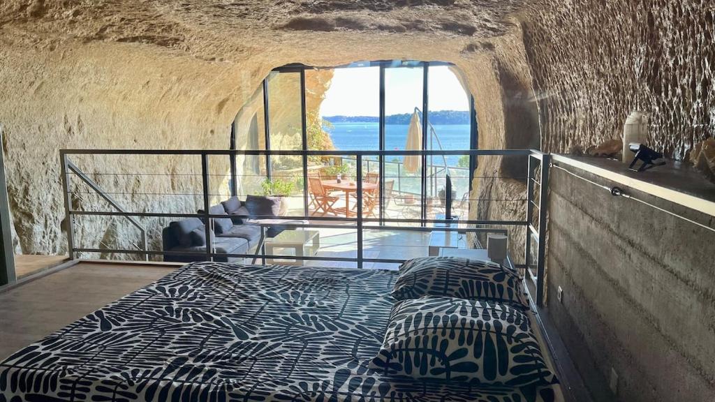 een bed in een kamer met uitzicht op de oceaan bij La Baume du Delà in Saint-Chamas