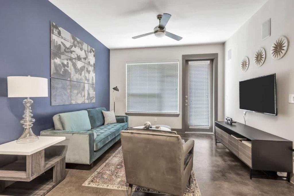 a living room with a couch and a tv at Boulevard Stays Elegant 1BR Pool Gym Parking in Richardson