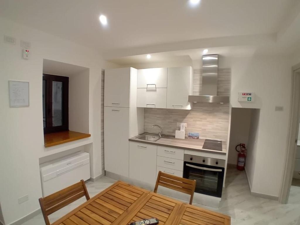 een keuken met witte kasten en een tafel en stoelen bij Al Borgo in Riano