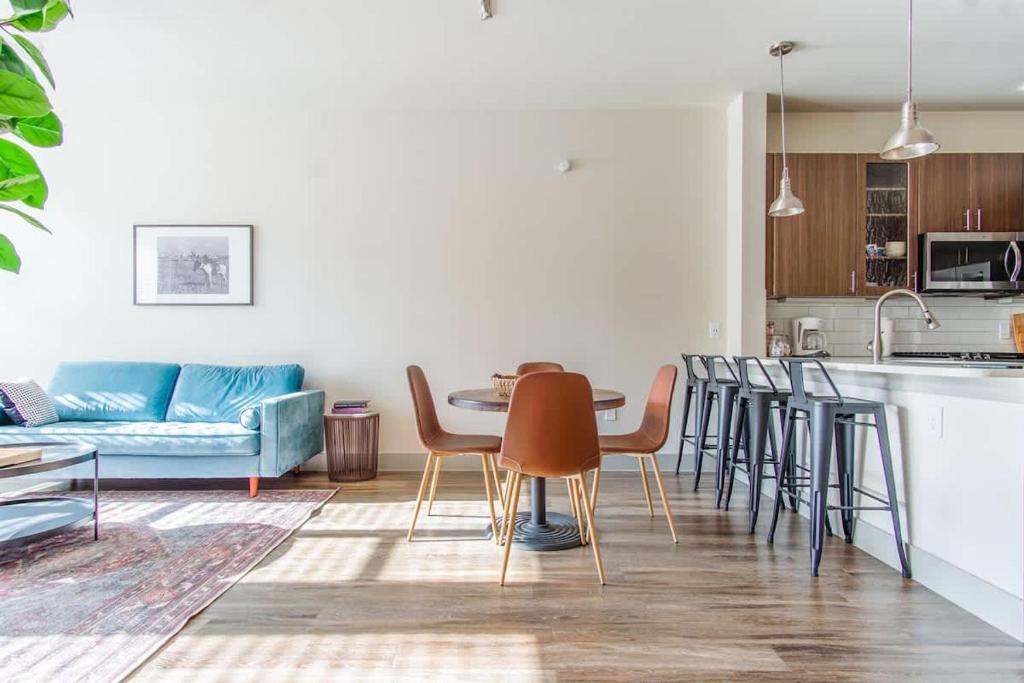 a kitchen and a living room with a table and chairs at Boulevard Stays Bright 1BR Suite Pool Parking Gym J in Richardson