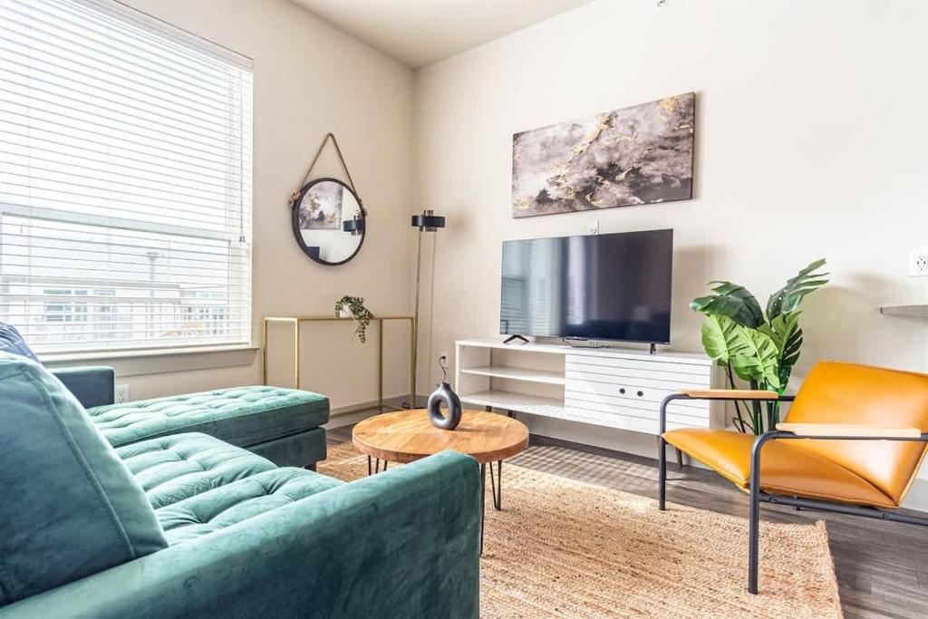 a living room with a couch and a tv at Boulevard Stays Dashing King Studio Suite Pool Parking Gym M in Richardson