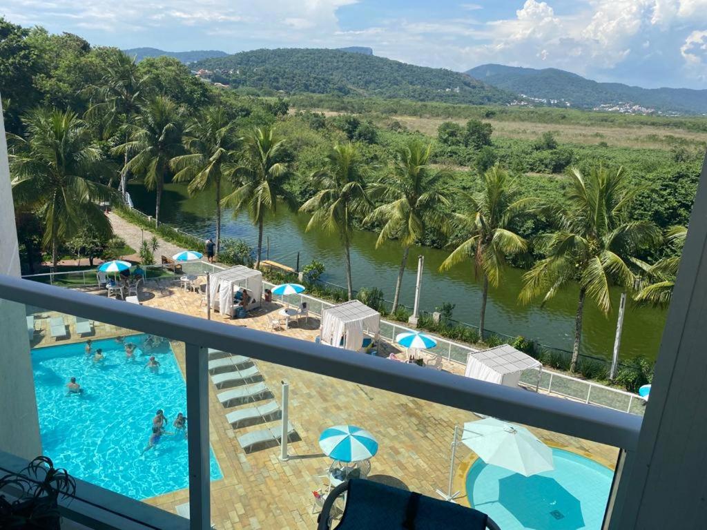 a view from a balcony of a pool and palm trees at Apartamento com piscina a poucos passos da praia in Niterói