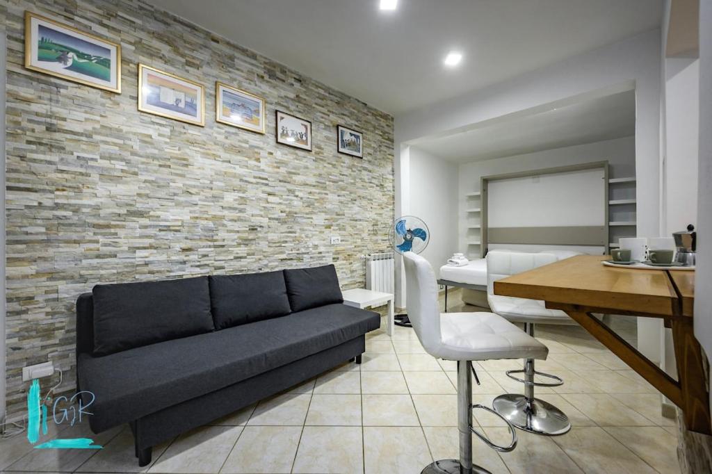 a living room with a couch and a brick wall at Chiabrera11 Aquarium - Genovainrelax in Genova