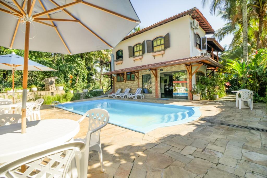 an exterior view of a house with a swimming pool at VELINN Feiticeira Praia Hotel in Ilhabela