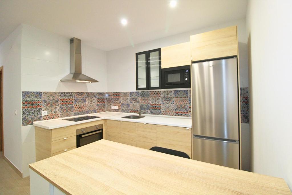 a kitchen with a stainless steel refrigerator and cabinets at Gran Vía 22 by SIERRA VIVA in Aracena