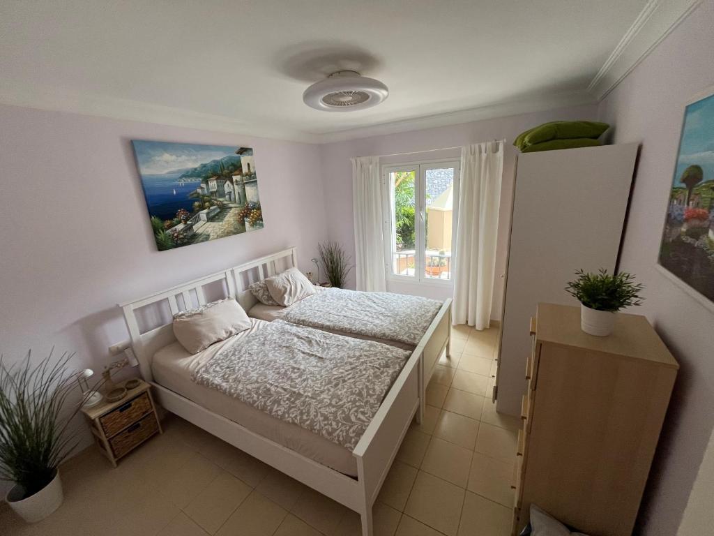 ein Schlafzimmer mit einem Bett und einem Fenster in der Unterkunft Residenz TraumBlick in Puerto de la Cruz