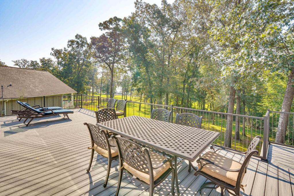 a wooden deck with a table and chairs on it at Waterfront Gilbertsville Retreat on Kentucky Lake! in Gilbertsville