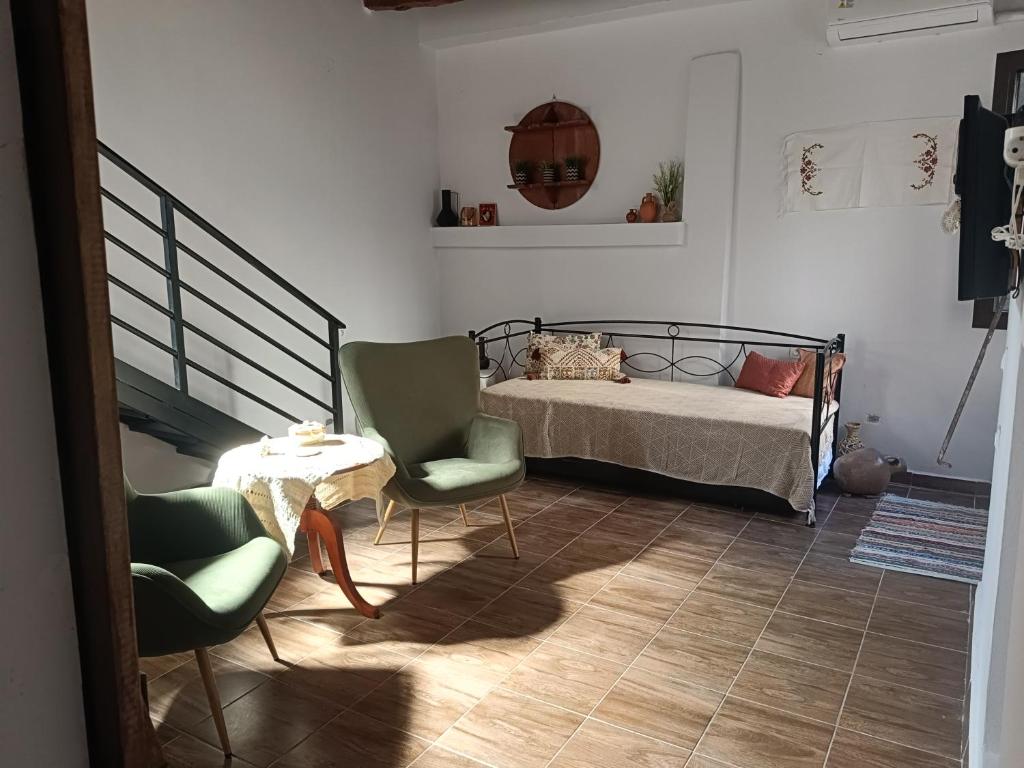 Un dormitorio con una cama y dos sillas y una mesa. en Archanes grandma's house, en Archanes