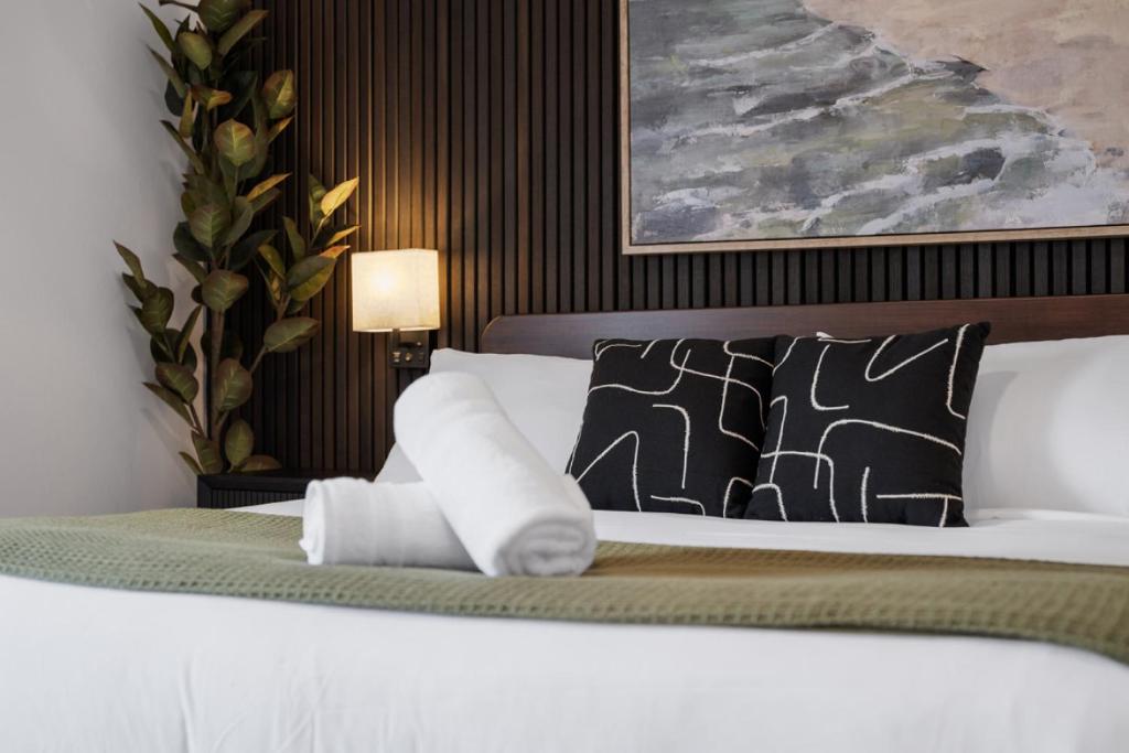 una camera con letto bianco e cuscini di PFR Suites - Highland, 3BR 2BA Shadyside Condo, Penthouse Unit, 2 Decks, Off-Street Parking, 4th Floor Walkup a Pittsburgh