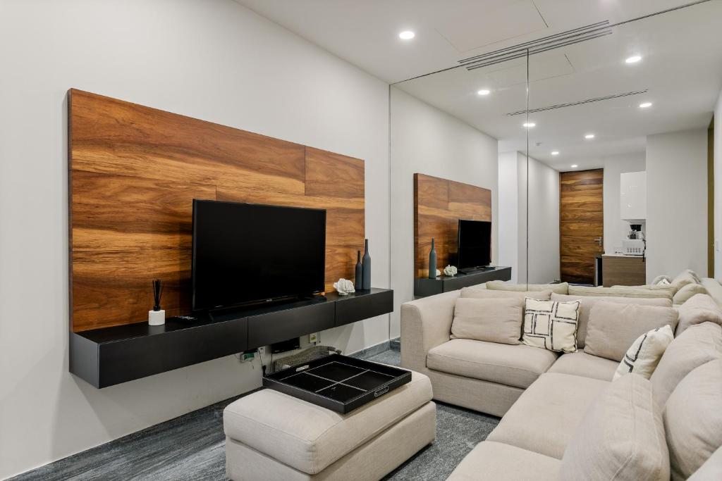 a living room with couches and a flat screen tv at Business studio-apartment near the beach in Cancún