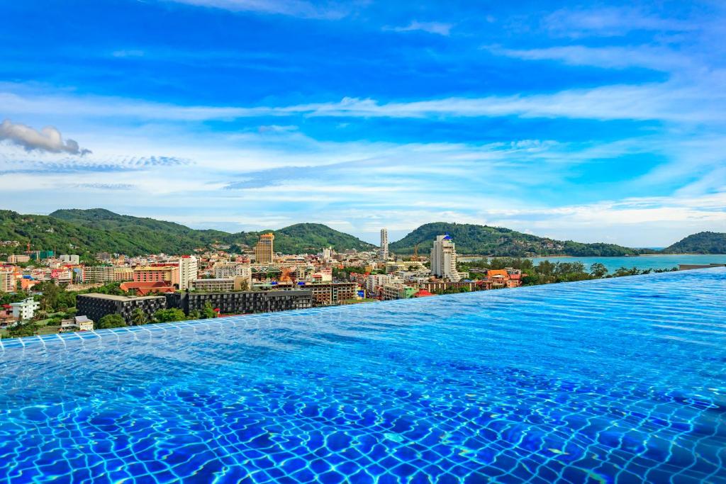 a infinity pool with a view of a city at Apartments at The Bliss Condo by Lofty in Patong Beach