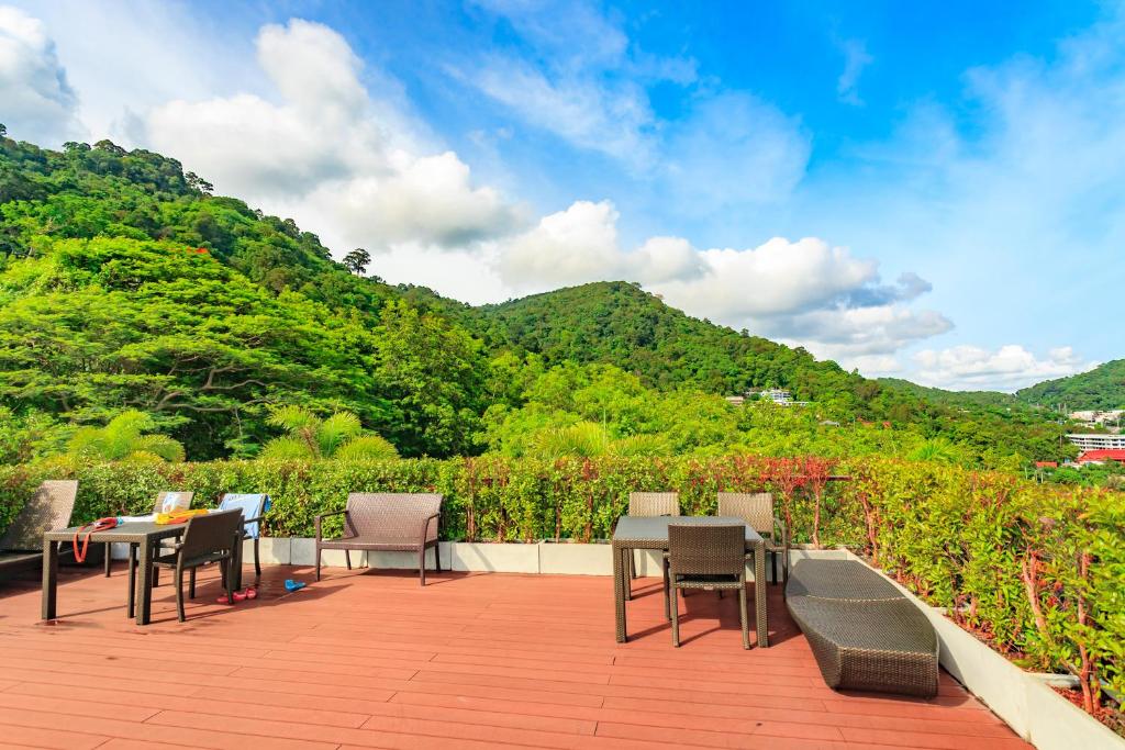 a patio with tables and chairs and a mountain at Apartments at The Bliss Condo by Lofty in Patong Beach