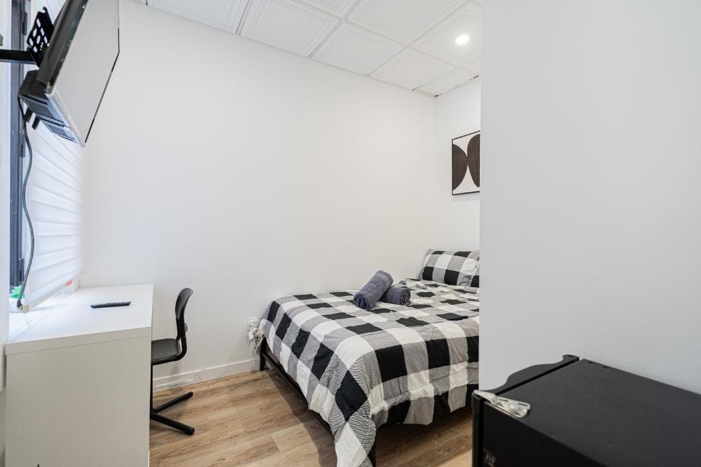 a bedroom with a bed with a black and white checkered blanket at Chambre 4 - appartement 2 dans un appartement PARTAGÉ in Montréal