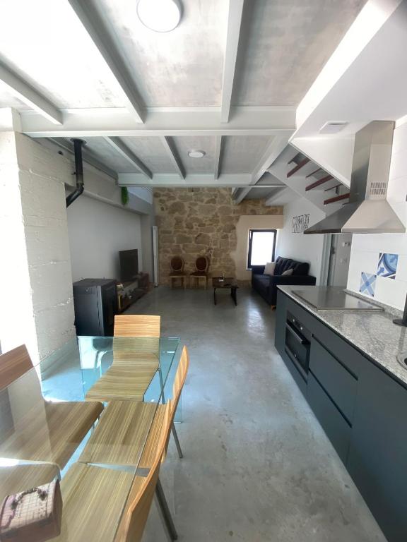 sala de estar con mesas de madera y cocina en Secreto del Tormes, en Cabrerizos