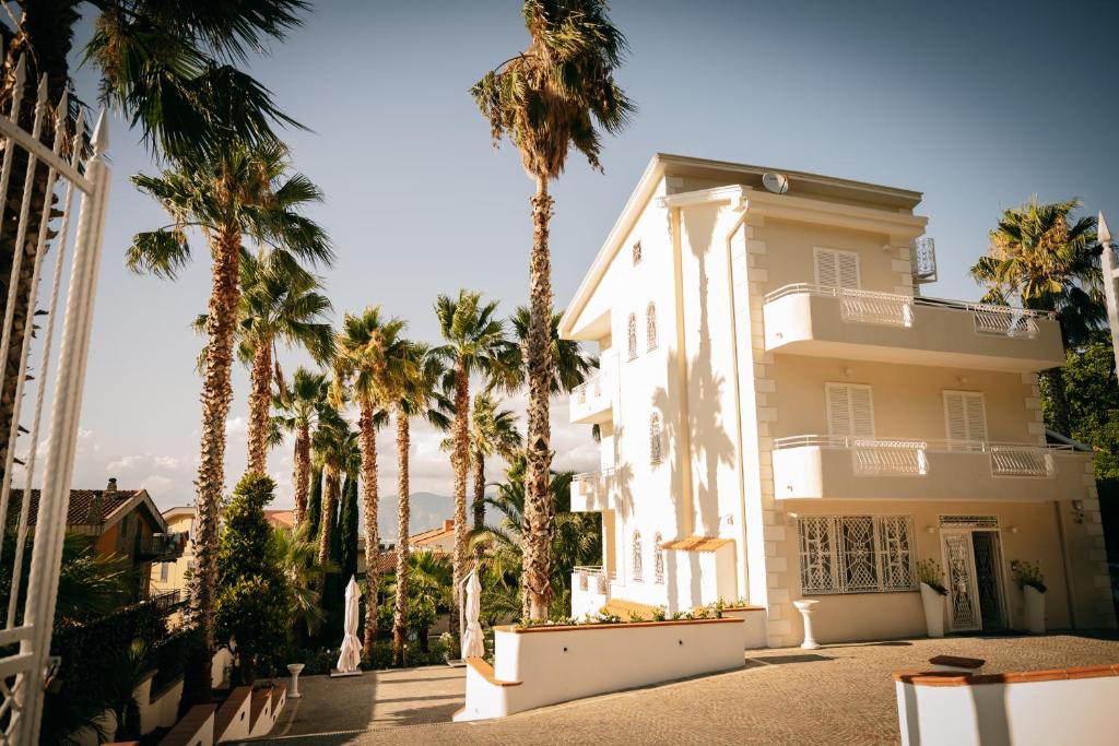 una casa blanca con palmeras delante en Villa Nicadè, en Corbara