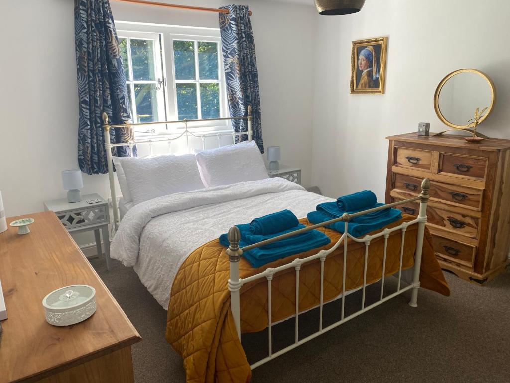 a bedroom with a bed and a table and a mirror at Annexe Orchard Cottage in Mersham